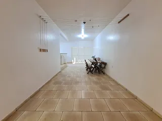 Corredor interno de uma residência com piso de cerâmica clara.