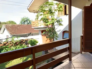 Vista da fachada de uma casa em Lajeado, Brasil, com uma varanda de madeira.