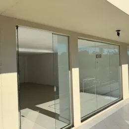Vista interna de um ambiente com grandes painéis de vidro.