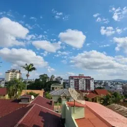 Vista panorâmica de edifícios na paisagem de Lajeado sob um céu azul com nuvens.