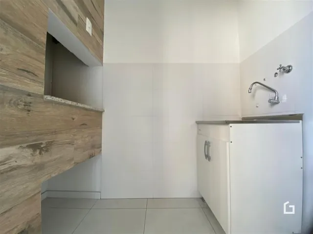 Foto de um ambiente interno com revestimento de madeira e azulejos brancos.