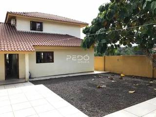 Fachada de uma casa em Lajeado, Brasil, com telhado de telhas e área externa coberta por cascalho.