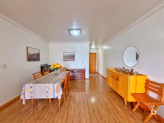 Uma sala de jantar com mesa de madeira e piso de madeira.