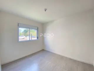 Ambiente interno de uma sala com piso de cerâmica e janela.