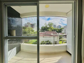 Vista da varanda com vista para casas e vegetação.
