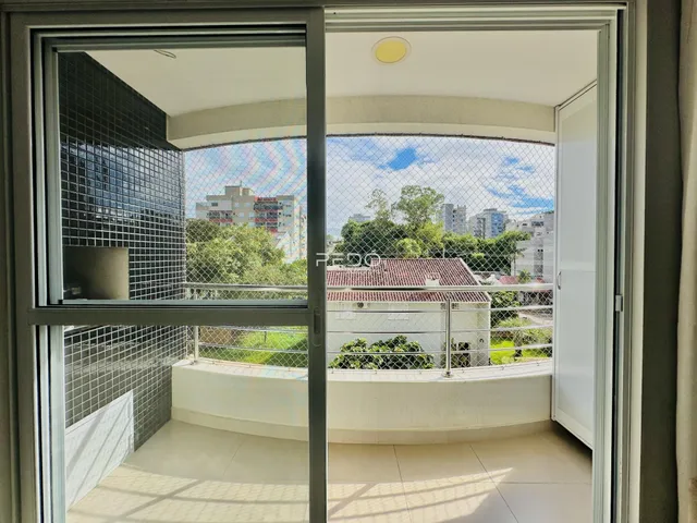 Vista da varanda com vista para casas e vegetação.