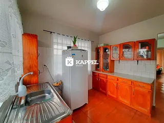 Foto de uma cozinha com bancada de aço inoxidável e armários de madeira.
