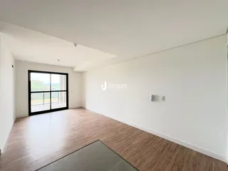 Sala de estar com piso de madeira e grande janela.