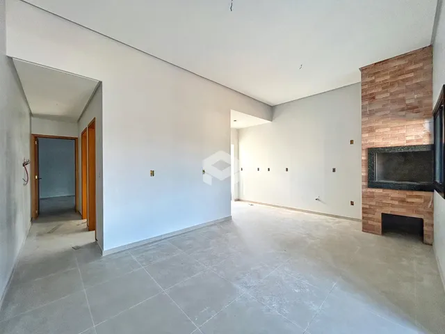 Ambiente interno amplo com paredes brancas e piso claro.
