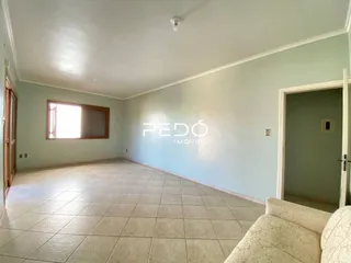 Foto de uma sala com piso de cerâmica clara e paredes brancas.