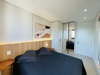 Quarto com cama e painel de madeira na decoração.