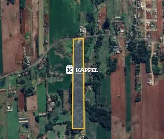 Vista aérea de uma área rural com campos agrícolas e vegetação.