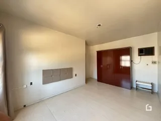 Ambiente interno de uma sala com paredes brancas e piso claro.