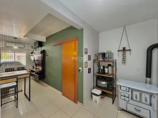 Interior de uma sala com porta de madeira e piso de cerâmica.