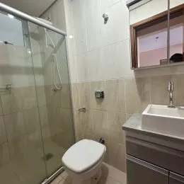 Foto de um banheiro com revestimento de azulejos brancos.