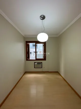 Hall de corredor com piso de madeira clara e paredes brancas.