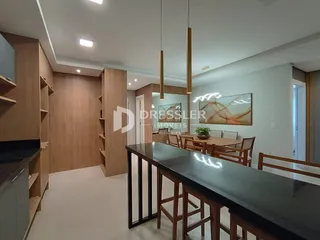 Interior de uma sala de estar moderna com móveis de madeira e piso claro.