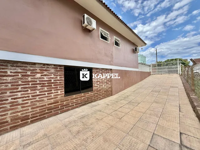 Fachada de uma residência em Lajeado, Brasil, apresentando paredes de tijolo aparente e pintura rosa.
