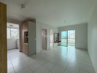 Sala de estar com piso de cerâmica branca e armários em madeira.