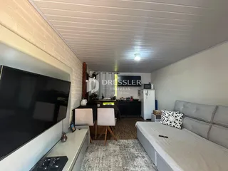 Sala de estar com sofá e televisão em um imóvel no Brasil.