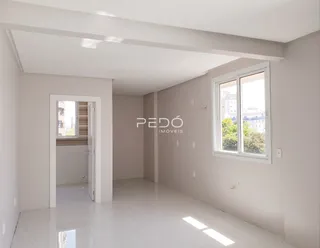 Foto de um ambiente interno claro com paredes brancas e piso reflexivo.