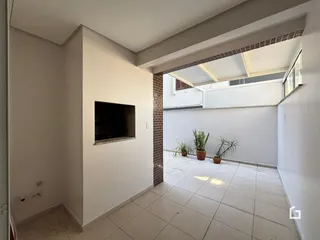 Interior de uma sala com piso de cerâmica e parede branca.