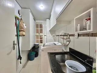 Cozinha moderna com armários brancos e revestimento de cerâmica.