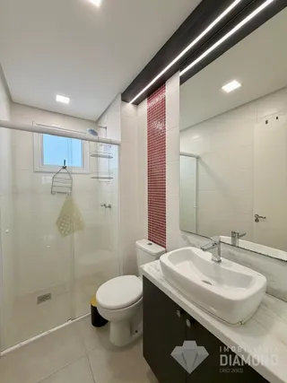 Banheiro moderno com pia branca e revestimento de azulejos na Lajeado, Brasil.