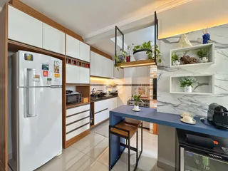 Cozinha moderna com armários brancos e madeira e ilha azul.