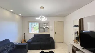 Sala de estar com sofá escuro e janela de madeira na residência.