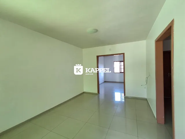 Hall de entrada com paredes brancas e piso de cerâmica.