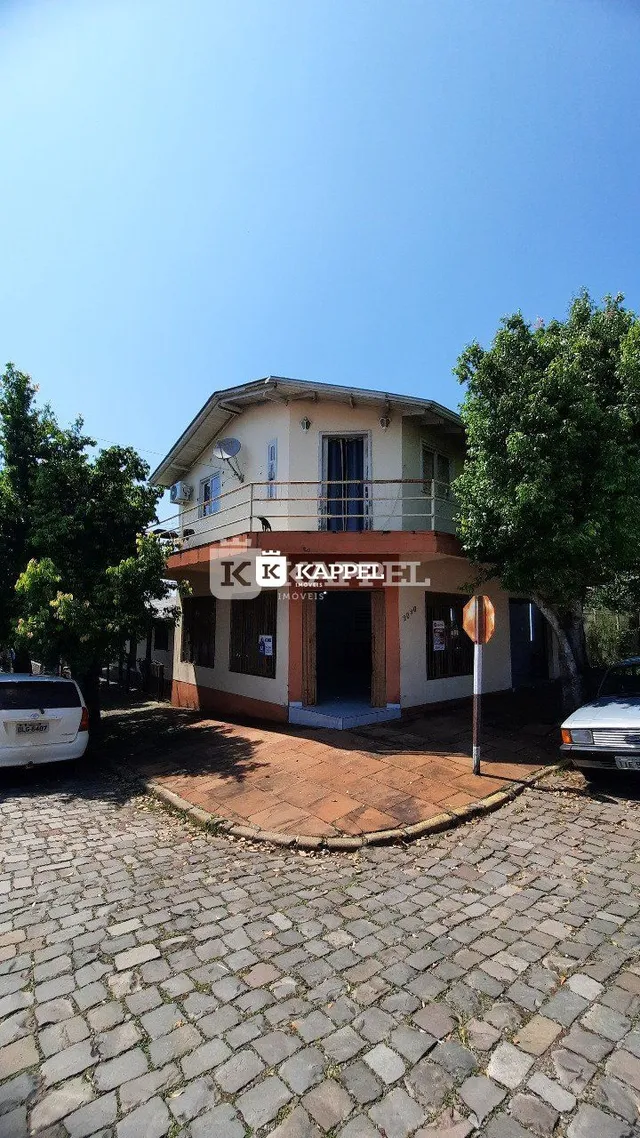 Fachada de uma casa em Lajeado, Brasil, com piso de paralelepípedos.