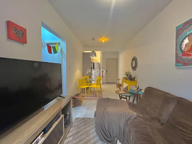 Sala de estar com sofá e televisão em um imóvel no Brasil.