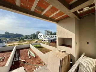 Foto da fachada de uma construção em andamento com vista para a paisagem rural.