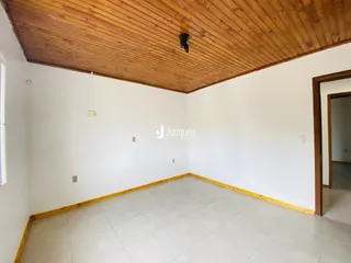 Interior de uma sala com piso de cerâmica e teto de madeira.