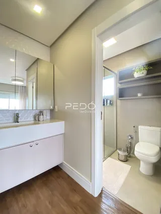 Vista de um corredor interno com armário e acesso a um banheiro.