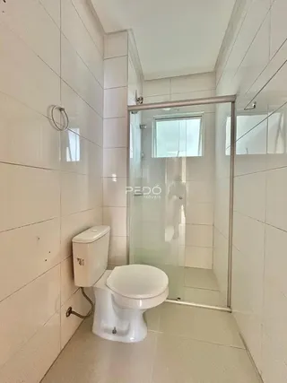Interior de um banheiro com revestimento cerâmico branco.