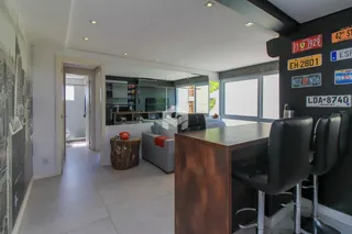 Sala de estar moderna com área de jantar e balcão em um imóvel no Brasil.
