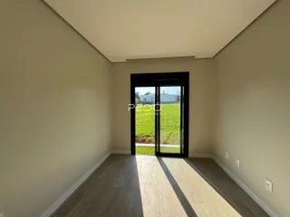 Interior de um ambiente com piso de madeira e porta de vidro voltada para o exterior.