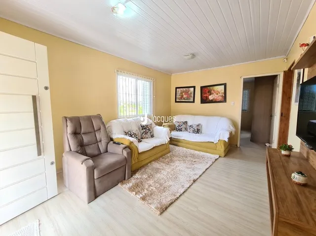 Sala de estar com sofá e poltrona em um ambiente claro.