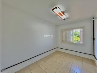 Foto de um cômodo interno com paredes brancas e piso de cerâmica.