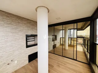 Ambiente interno com piso de madeira clara e parede texturizada em um imóvel.