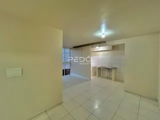 Vista de um corredor interno com piso de cerâmica branca.