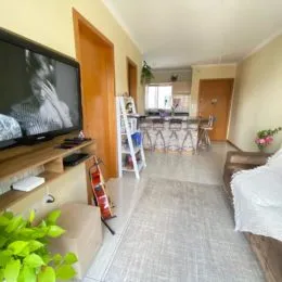 Ambiente interno com mesa de jantar de madeira e piso claro.