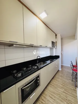 Foto de uma cozinha moderna com armários brancos e bancada preta.