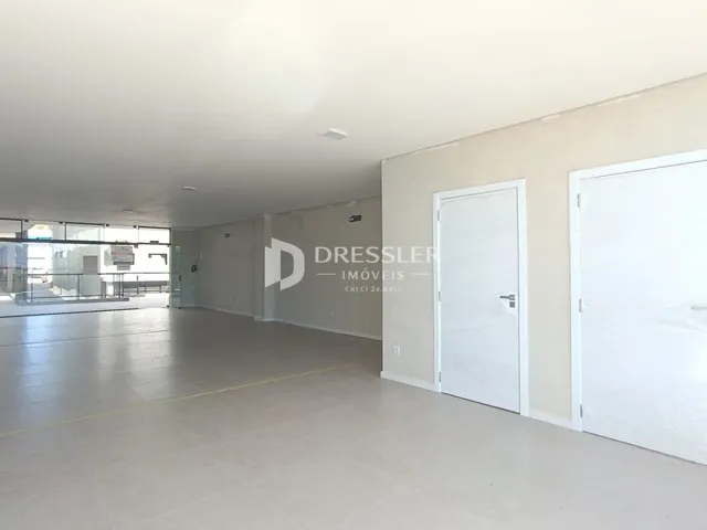Espaço interno amplo com paredes brancas e portas brancas.