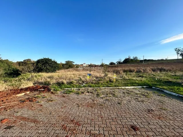 Vista externa de uma área pavimentada com tijolos vermelhos em um terreno aberto.
