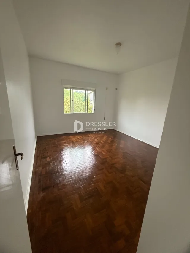 Vista de um corredor com piso de madeira no imóvel.