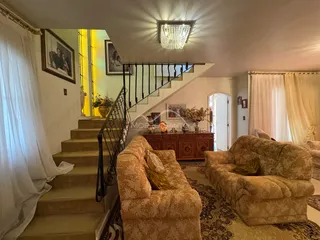 Hall de entrada com escadas e dois sofás grandes em uma sala comum.