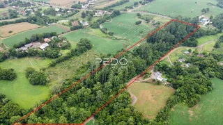 Vista aérea de uma propriedade rural com áreas de mata e campos.